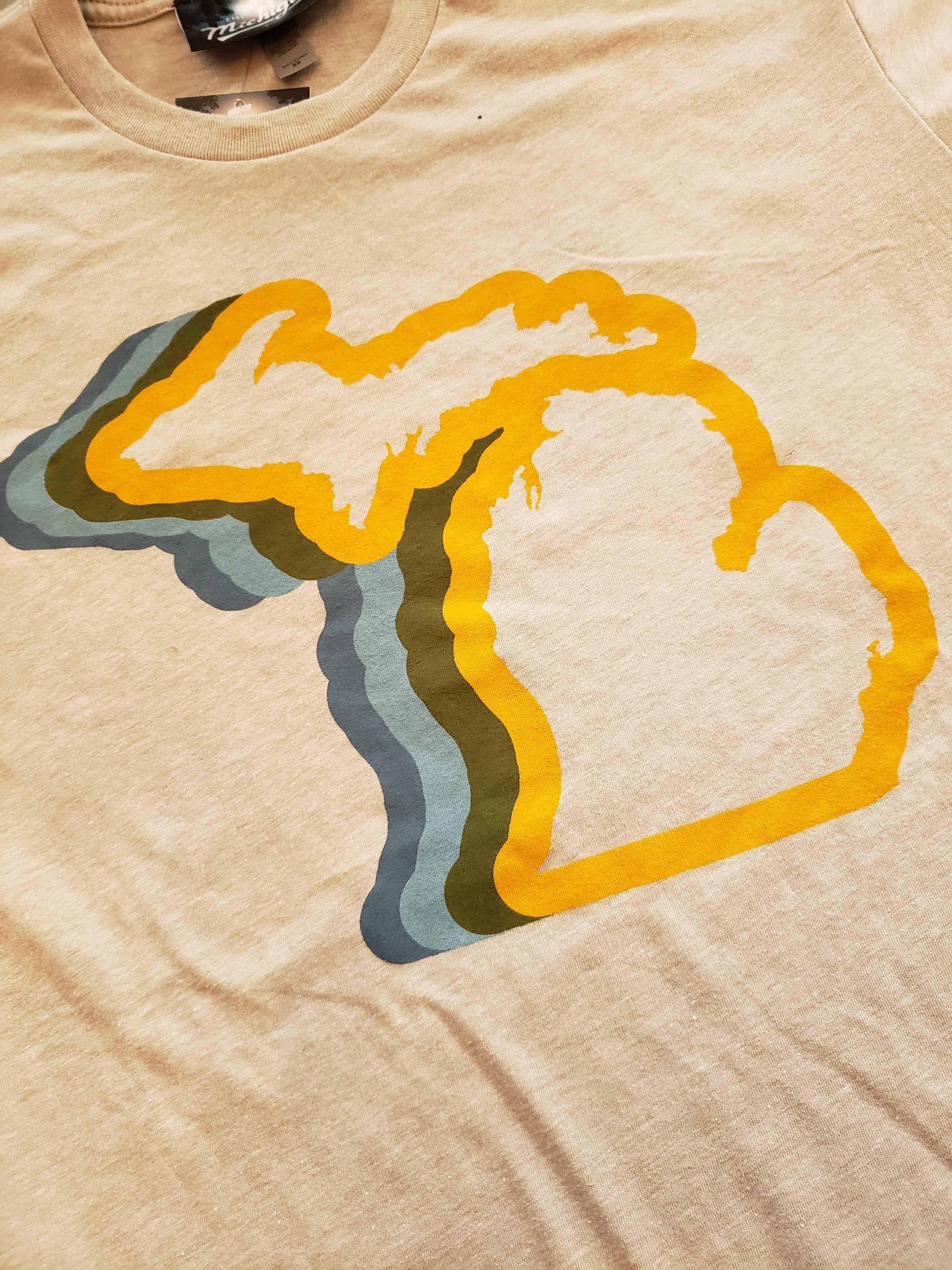 Michigan T-shirt by Enjoy Michigan - Our premium Michigan 70's design showing the state of Michigan outlined in a blue to yellow color wave